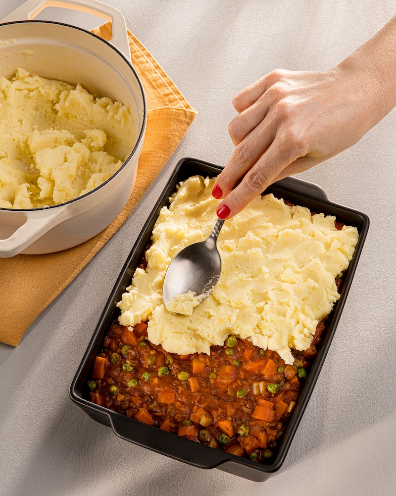 Dieses Bild zeigt wie mit Kartoffelpüree abgedeckt wird.