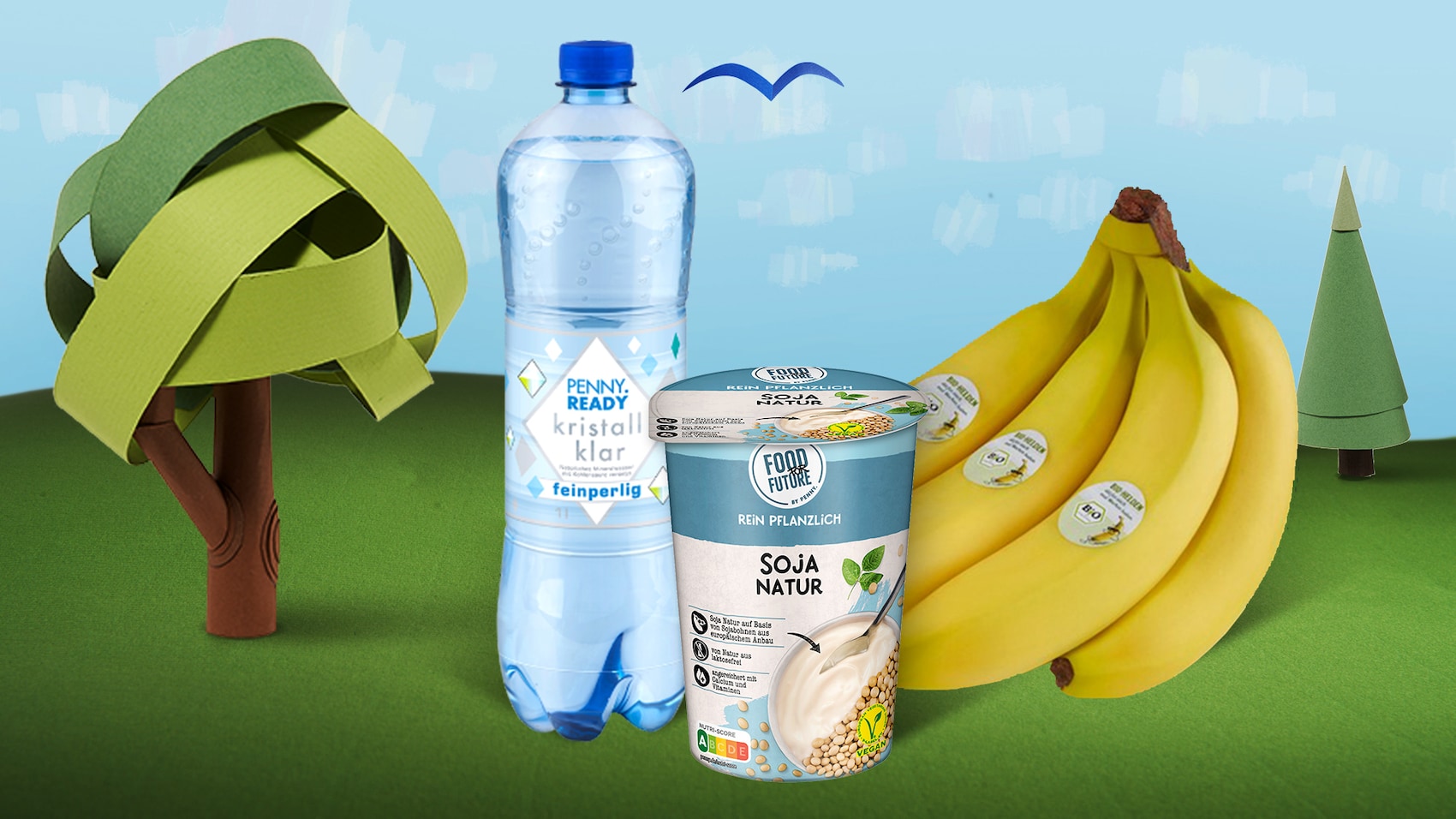 Naturgut Käse, PENNY Ready Cafe Latte und Bananen auf blauem Hintergrund