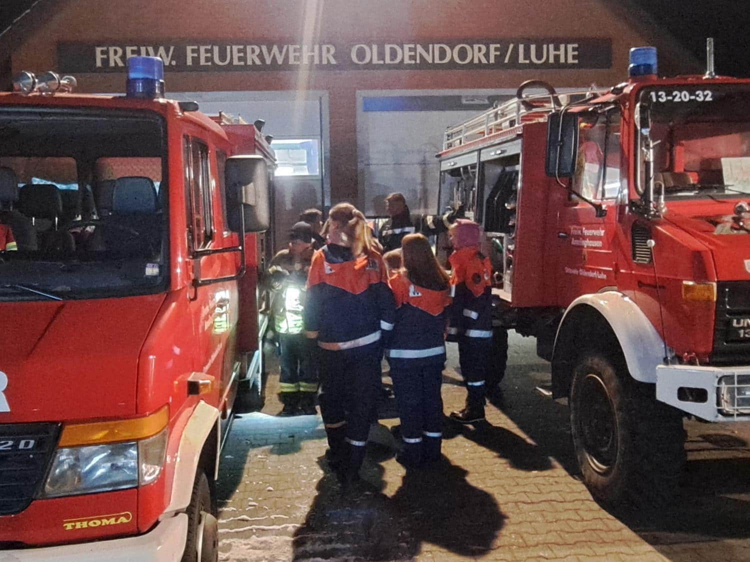 Vereinsmitglieder und Kinder an einem Feuerwehrauto