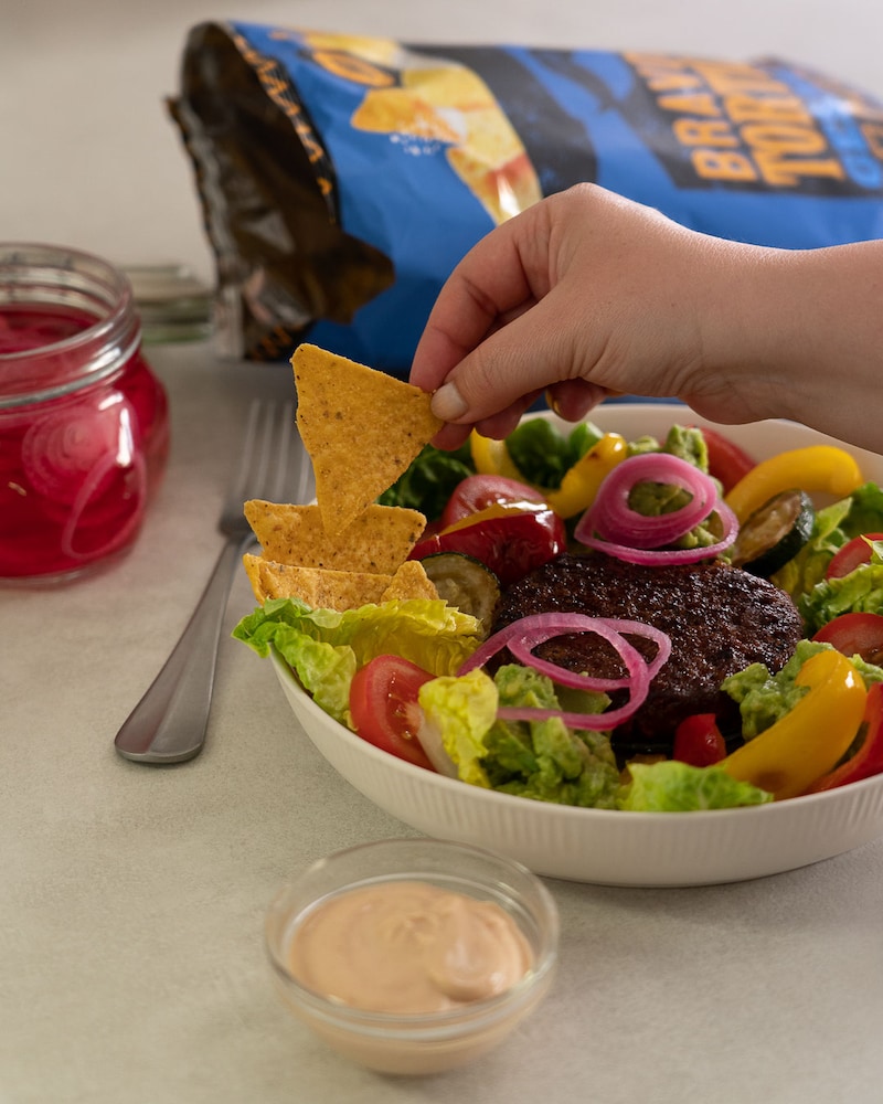 Dieses Bild zeigt wie die Nachos dazugegeben werden.
