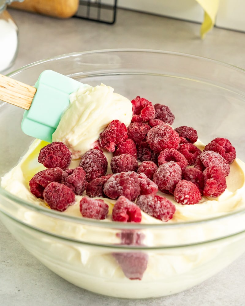 Dieses Bild zeigt wie die Himbeeren in die Creme untergehoben werden.