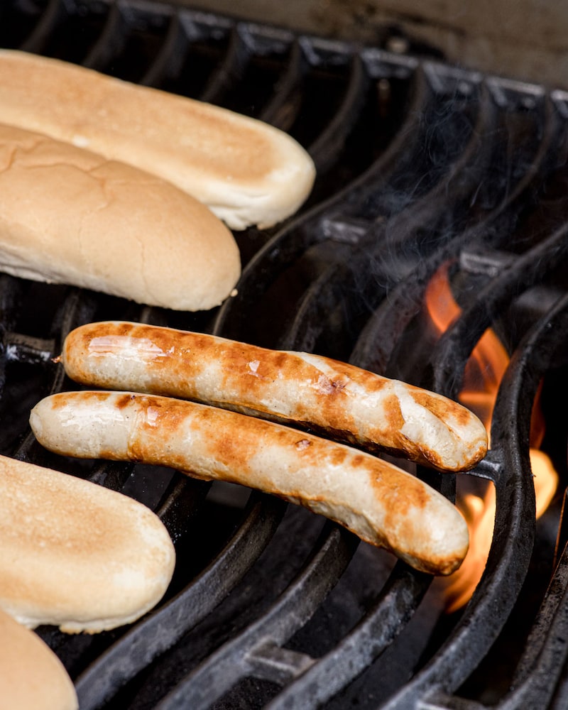 Dieses Bild zeigt die Rostbratwurst und die Brötchen auf dem Grill.