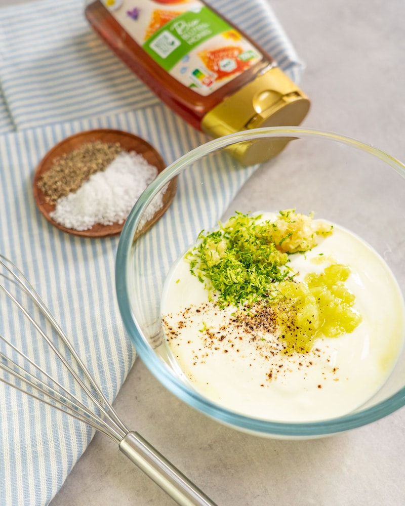 Dieses Bild zeigt wie der Joghurt, Honig, Salz und Pfeffer in die Schüssel gegeben und alles kräftig verrührt wird.
