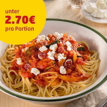 Auf diesem Bild siehst du wie Feta über die Spaghetti gestrudelt wird.