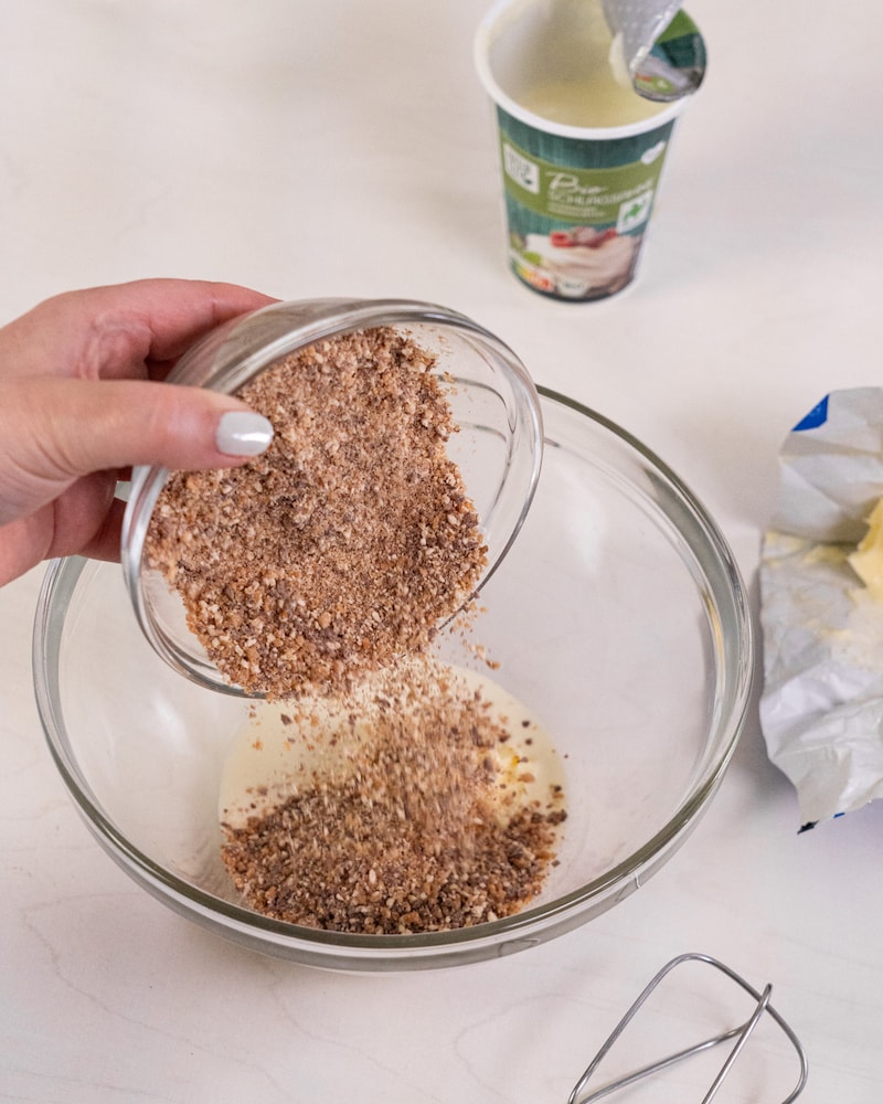 Dieses Bild zeigt das hinzufügen der Erdnuss Riegel für die Karamell-Ganache.