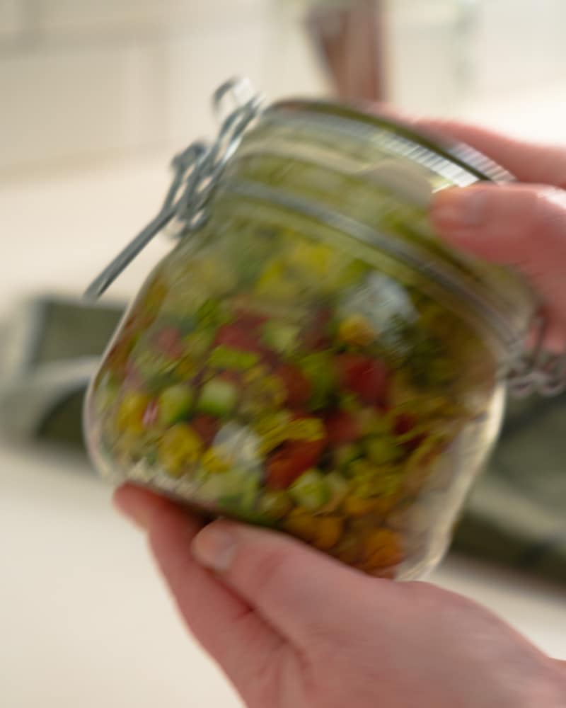 Auf diesem Bild siehst du wie das Salat Glas geschüttelt wird.