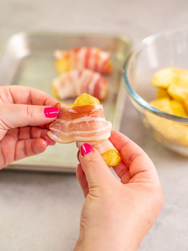 Dieses Bild zeigt wie der Bacon um die Äpfel gelegt wird.