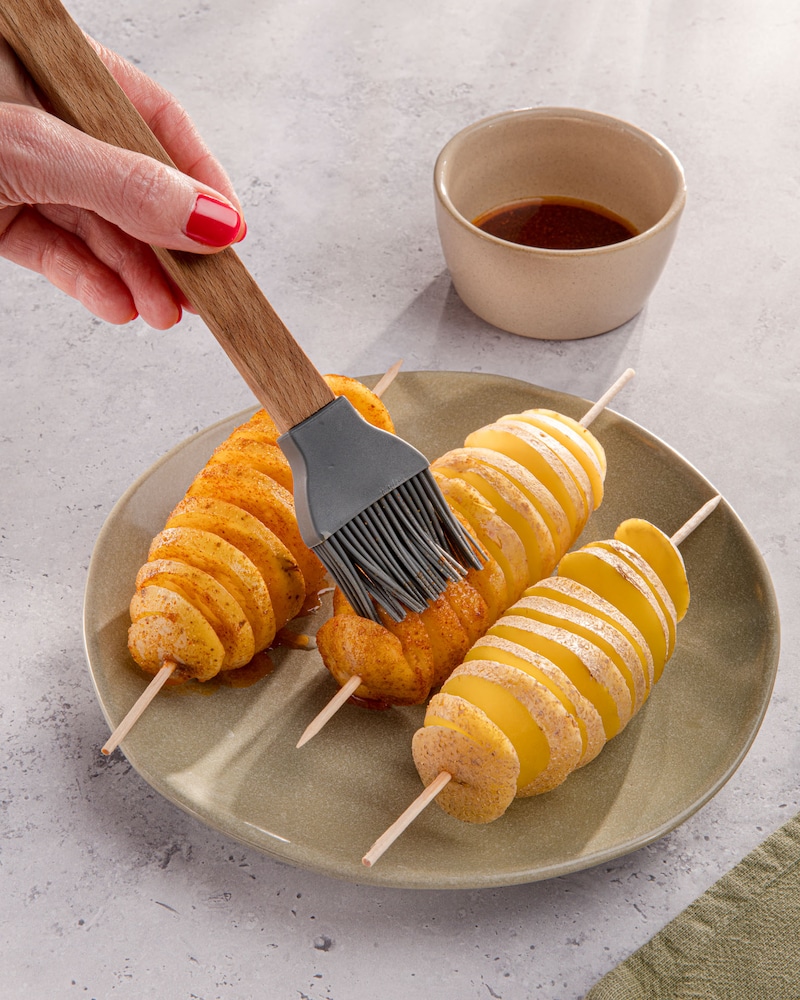 Dieses Bild zeigt, wie die Kartoffeln bepinselt werden.