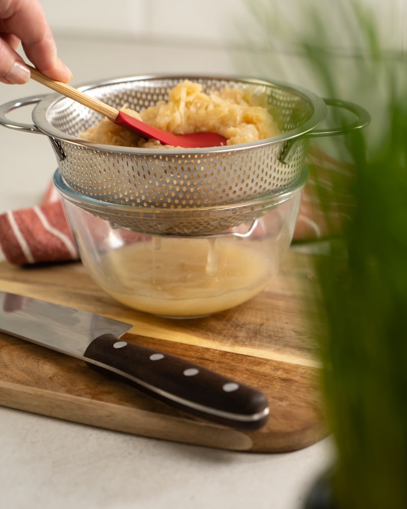 Auf diesem Bild siehst du wie das Sauerkraut abgetropft wird.