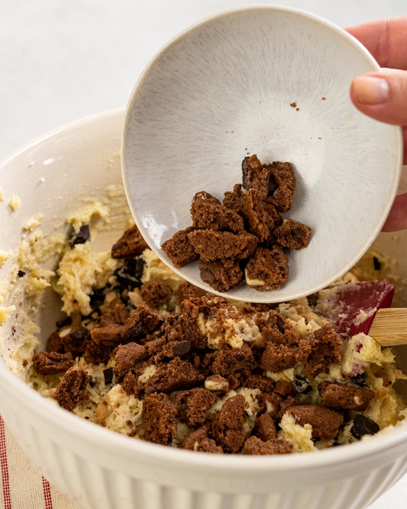 Auf diesem Bild siehst du wie Cookie-Krümel zum Teig gegeben wird.