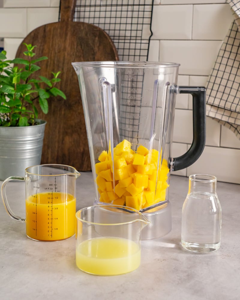 Dieses Bild zeigt wie den Limettensaft und die Mango im Mixer.