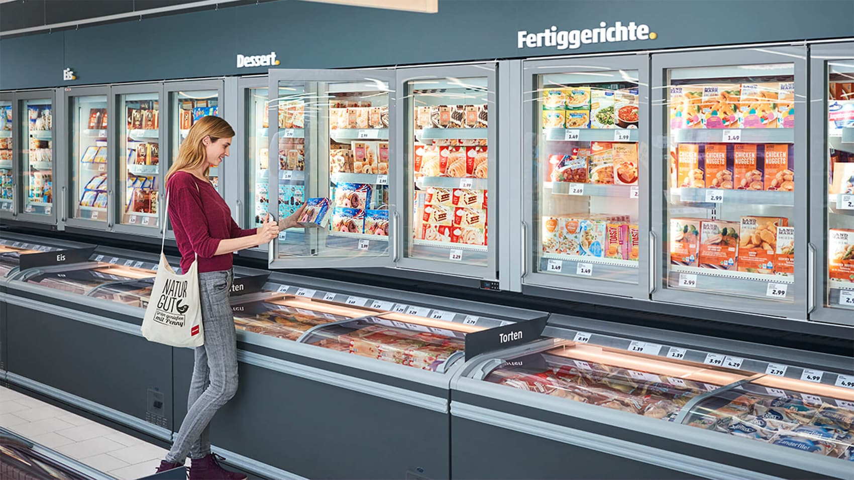 Eine Kundin findet im neuen Kühlregal, alles was sie braucht.