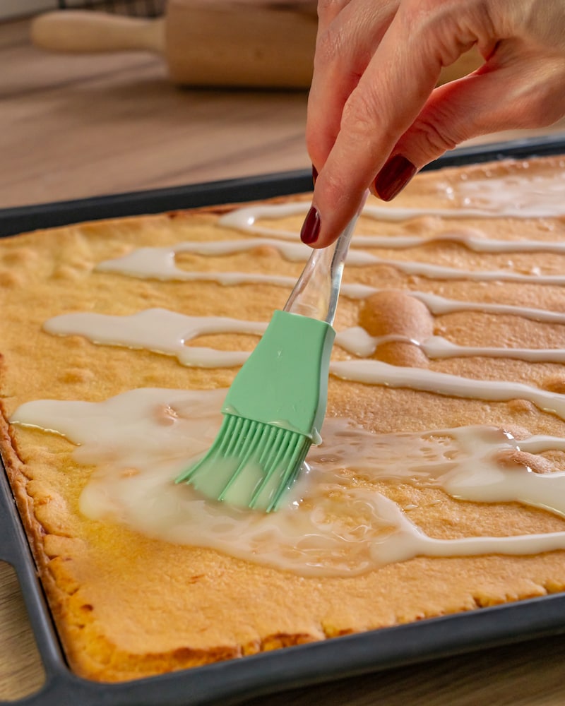 Dieses Bild zeigt wie der Zuckerguss auf dem Kuchen verstrichen wird.
