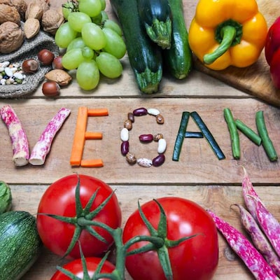 Vegan Schriftzug aus Zutaten auf Holztisch