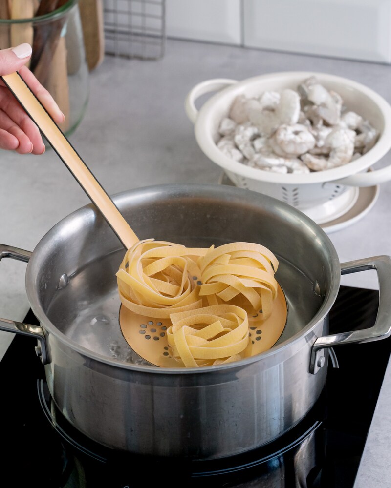 Dieses Bild zeigt wie die Bandnudeln zum kochenden Wasser gegebenen wird.