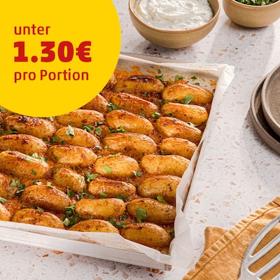 Dieses Bild zeigt wie Kräuter über den Kartoffeln verteilt werden.