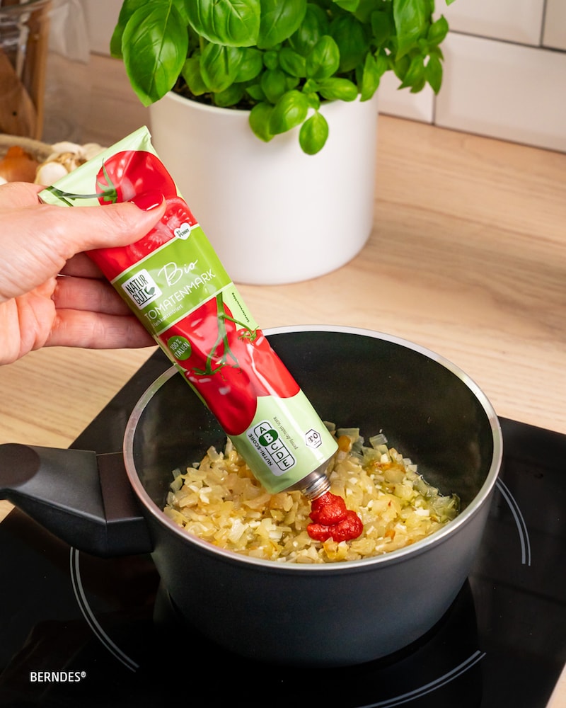 Dieses Bild zeigt wie das Tomatenmark hinzugegeben wird.