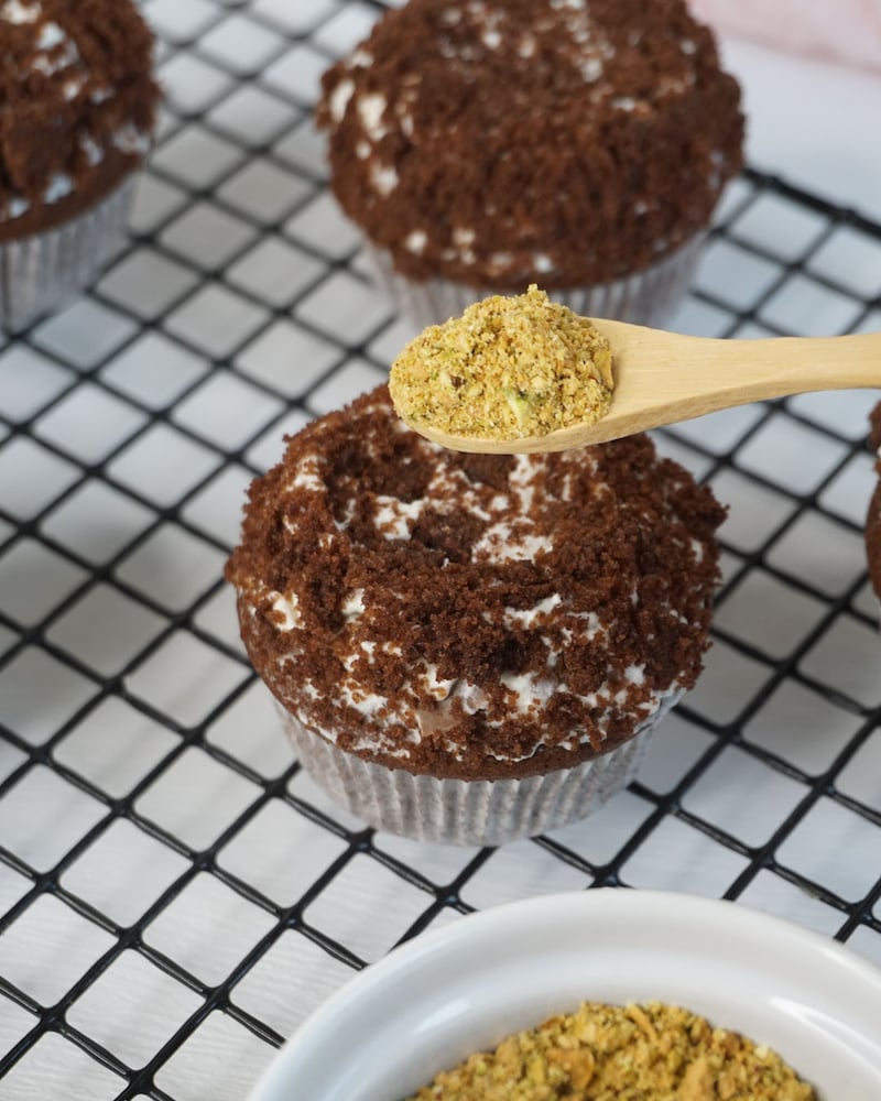 Dieses Bild zeigt wie die Pistazien auf den Muffin gegeben werden.