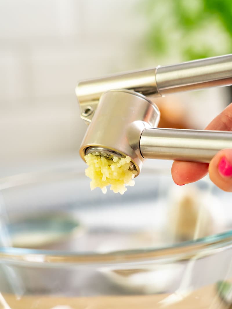 Dieses Bild zeigt wie der Knoblauch gepresst wird.