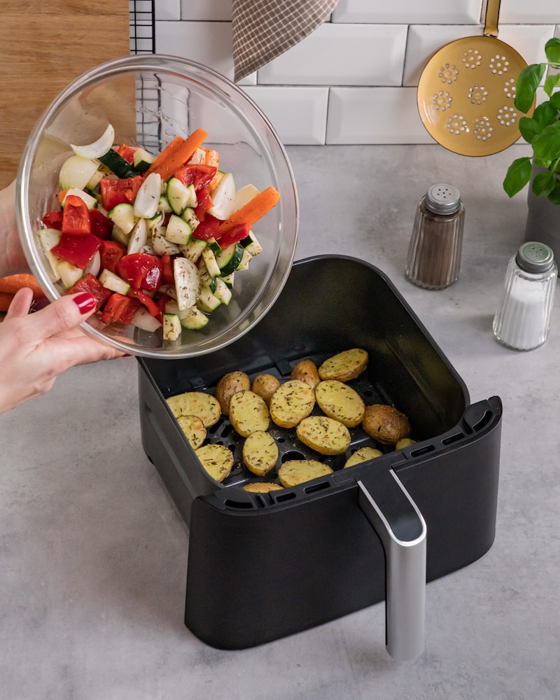 Dieses Bild zeigt wie das Gemüse zu den Kartoffeln gegeben wird.