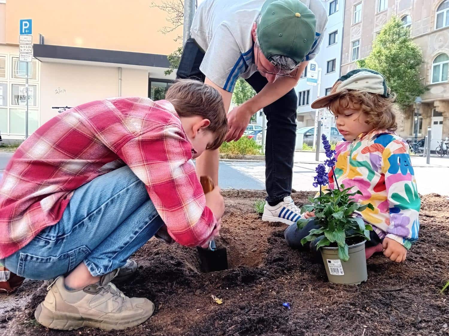 Kinder pflanzen eine Blume in die Erde