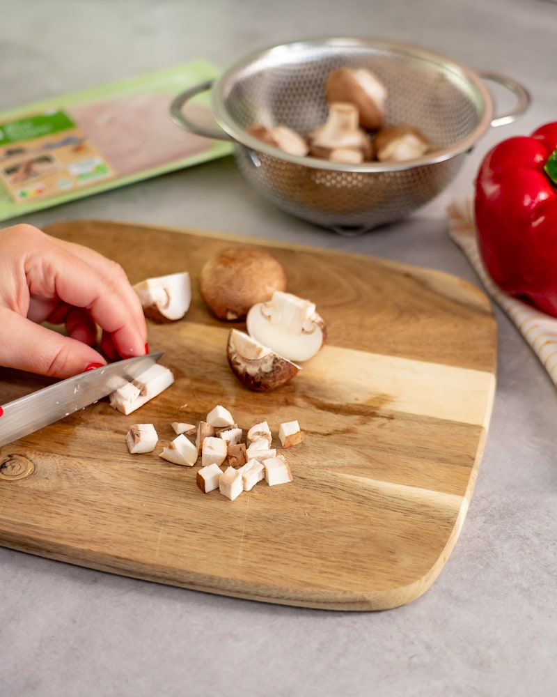 Dieses Bild zeigt wie die Champignons klein geschnitten werden.