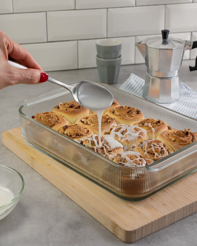 Dieses Bild zeigt wie die Schnecken mit Zuckerguss übergossen werden.
