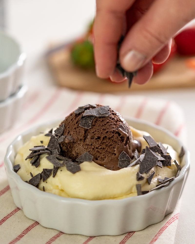 Auf diesem Bild siehst du wie Schokostreusel über das Eierlikör-Dessert gegeben werde.