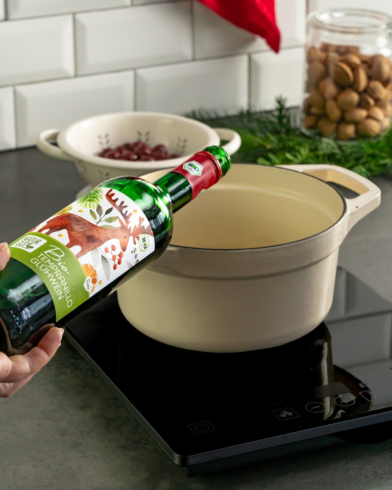 Dieses Bild zeigt wie der Glühwein in den Topf gegeben wird.