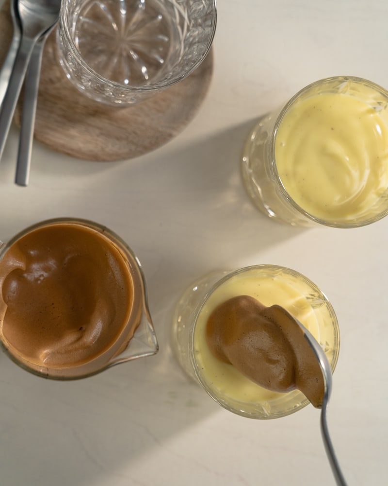 Auf diesem Bild siehst du wie Kaffeecreme dazugegeben wird.