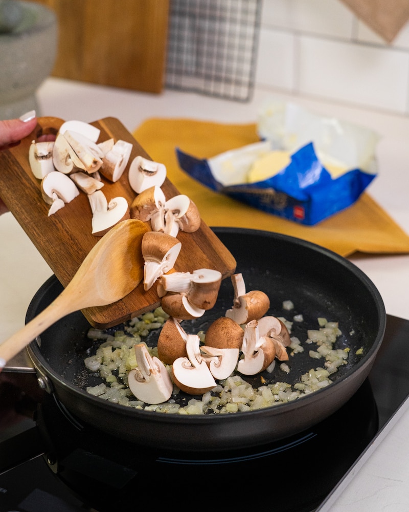 Dieses Bild zeigt das hinzufügen der frischen Zutaten der Pasta mit Pilzrahm.