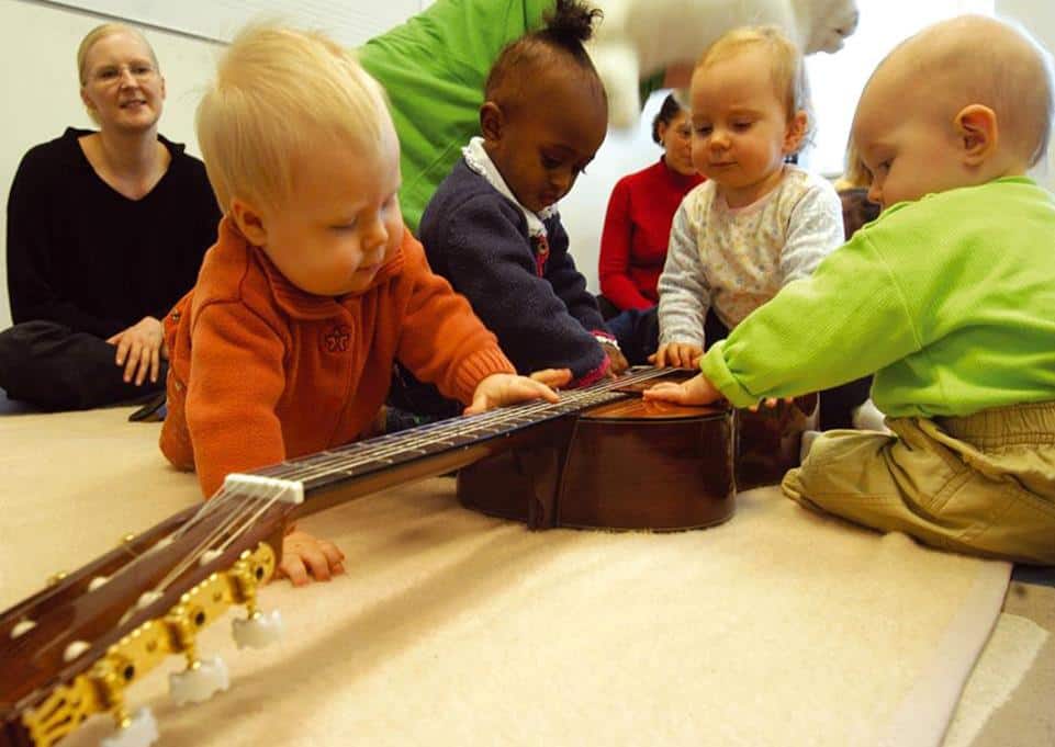 Babys spielen an einer Gitarre