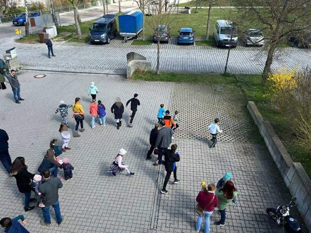 Kinder rennen gluecklich auf dem Hof der Feuerwehr