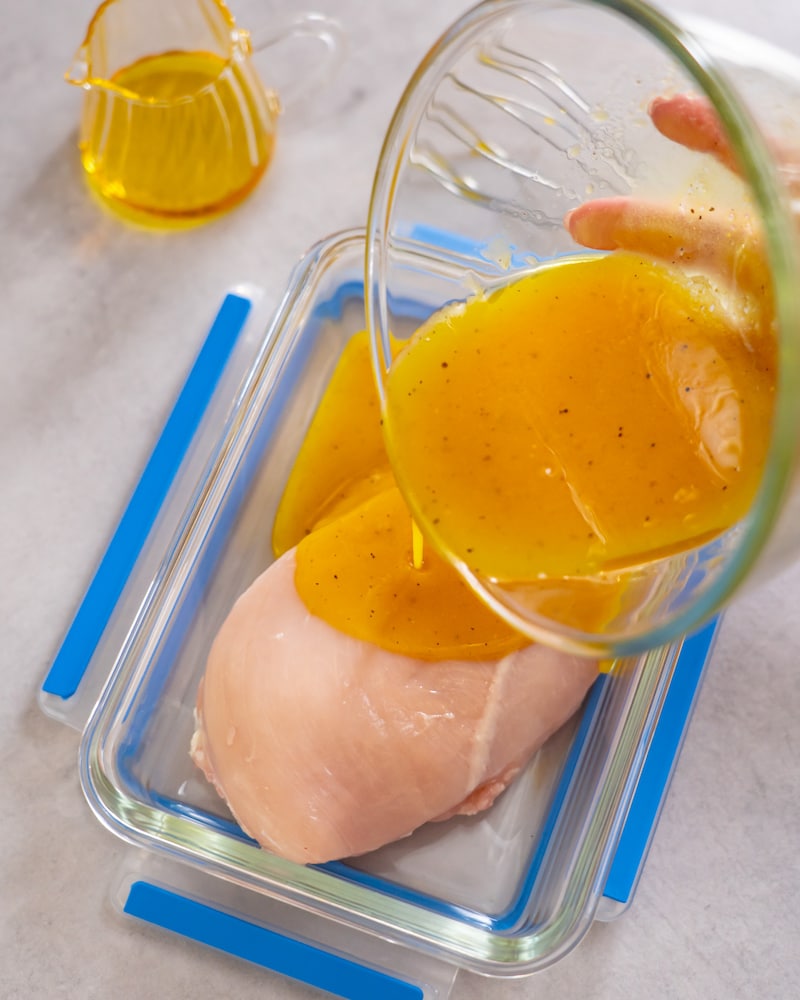 Dieses Bild zeigt wie das Fleisch mit Honig, Senf, Rapsöl, Essig und Pfeffer begossen wird.