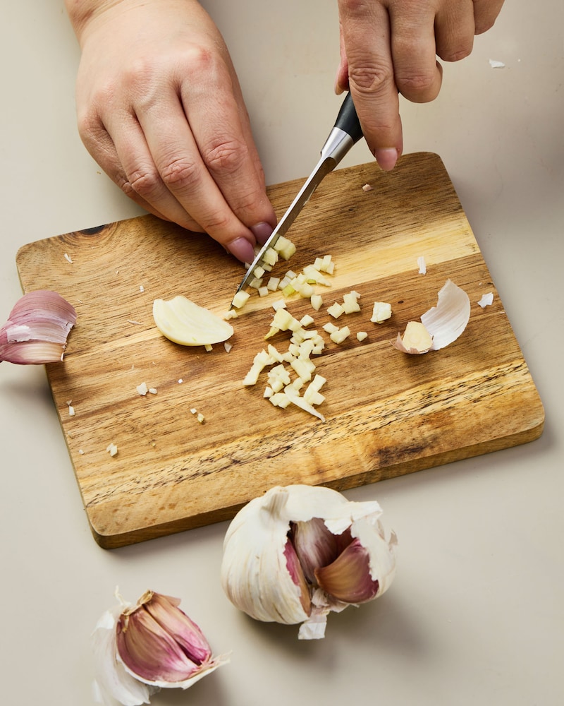 Dieses Bild zeigt wie der Knoblauch gehackt wird.
