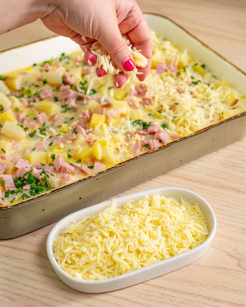 Dieses Bild zeigt wie der Käse darüber gestreut wird.