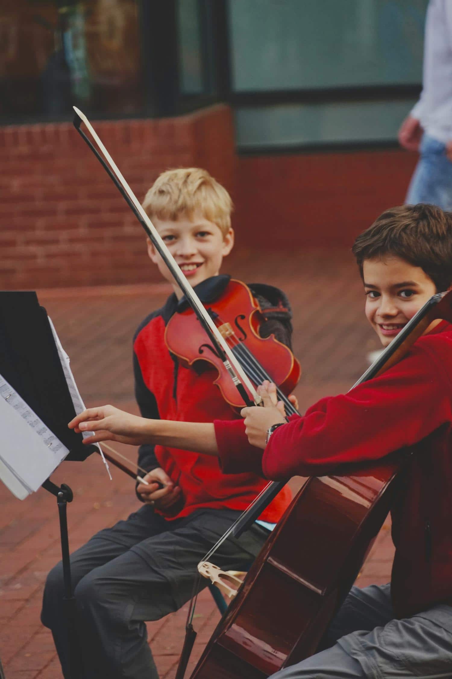 Kinder bei ihrern Musikproben laecheln in die Kamera