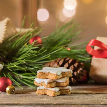 Zimtsterne, die vor Weihnachtsdeko liegen.