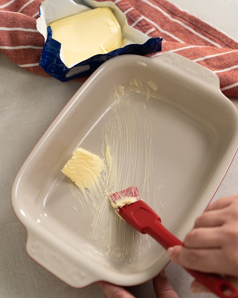 Auf diesem Bild siehst du wie eine Auflaufform eingefettet wird.