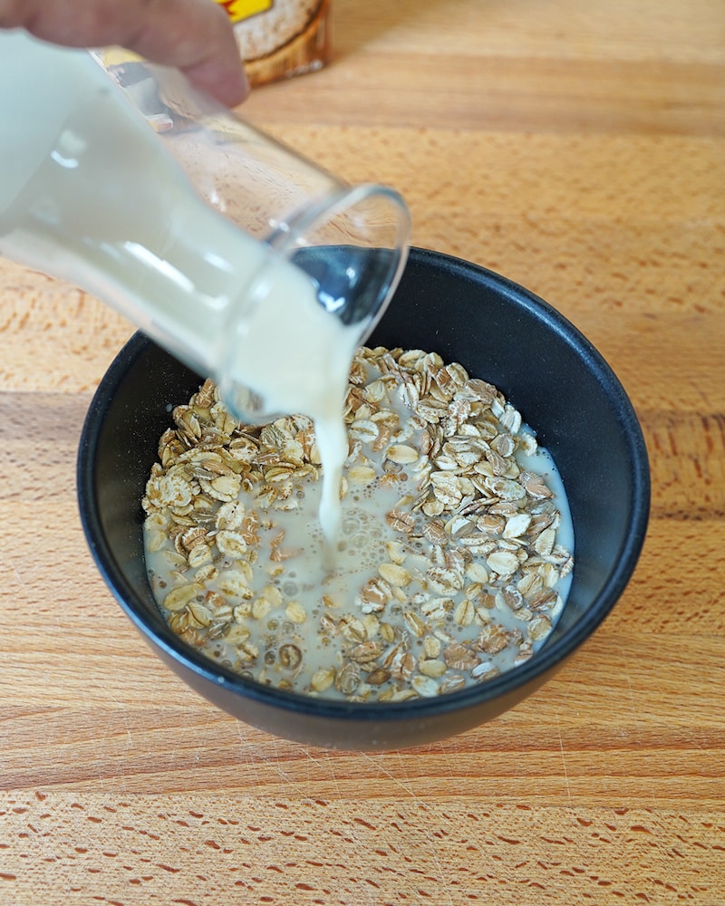 Dieses Bild zeigt wie Milch in Haferflocken gegeben wird.