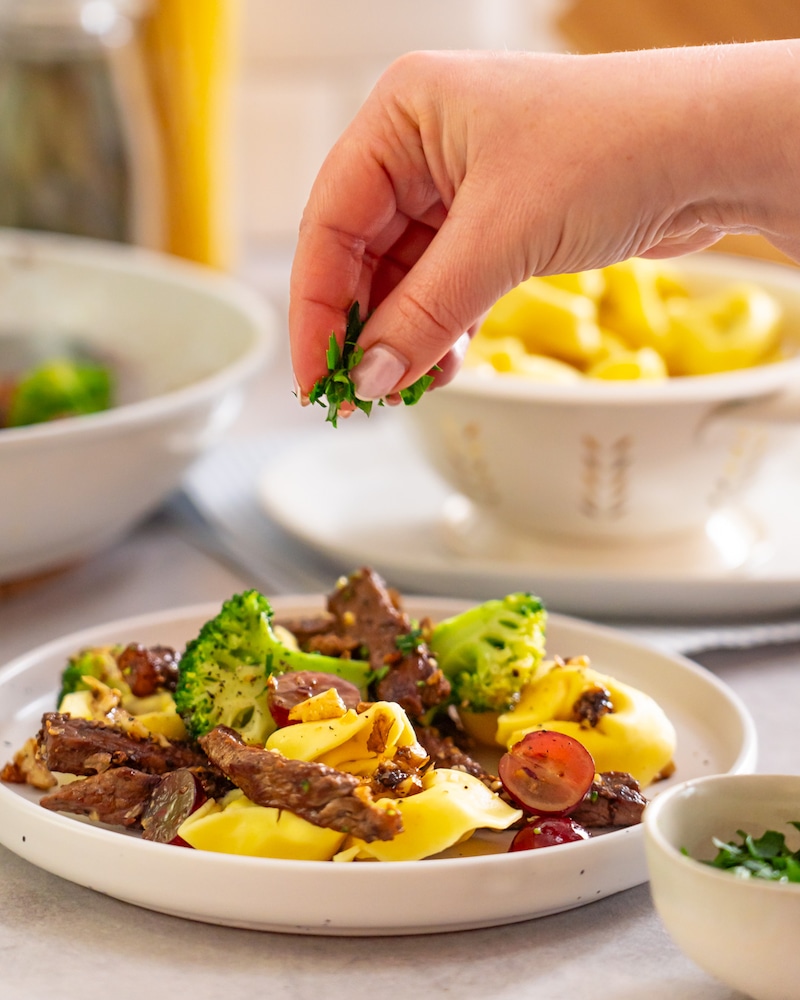 Dieses Bild zeigt wie die Tortelloni Proscuitto garniert wird.