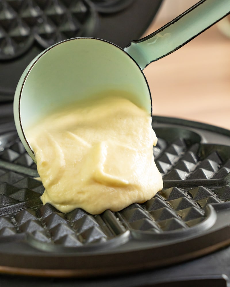 Dieses Bild zeigt wie der Teig in das Waffeleisen gegeben wird.