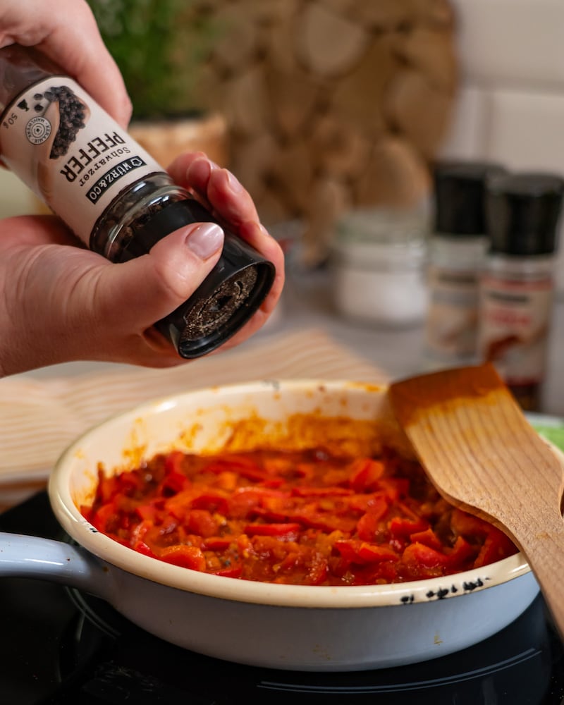 Dieses Bild zeigt das würzen des Shakshuka.