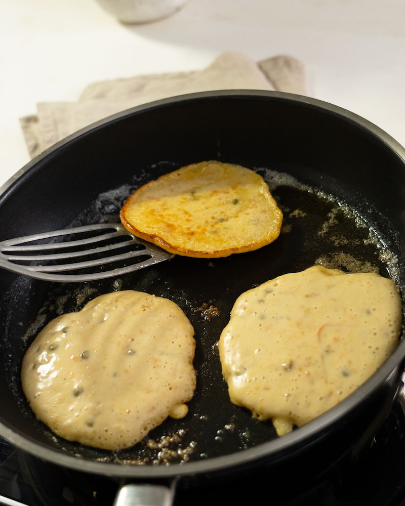 Dieses Bild zeigt wie Pfannkuchen in der Pfanne gebraten werden.