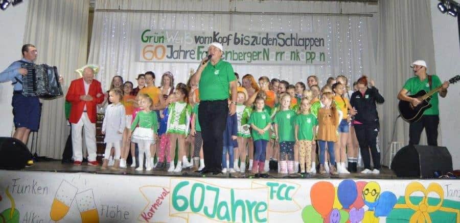 Kinder und Vereinsmitglieder singen auf der Buehne