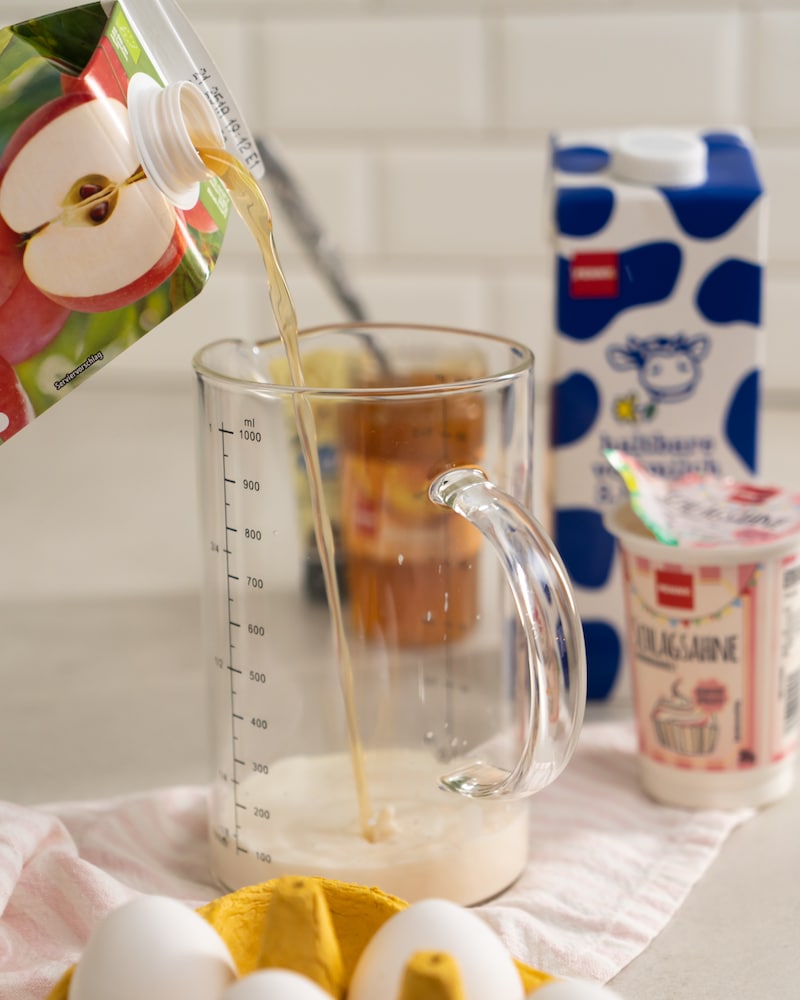 Auf diesem Bild siehst du wie Apfelsaft dazugegeben wird.