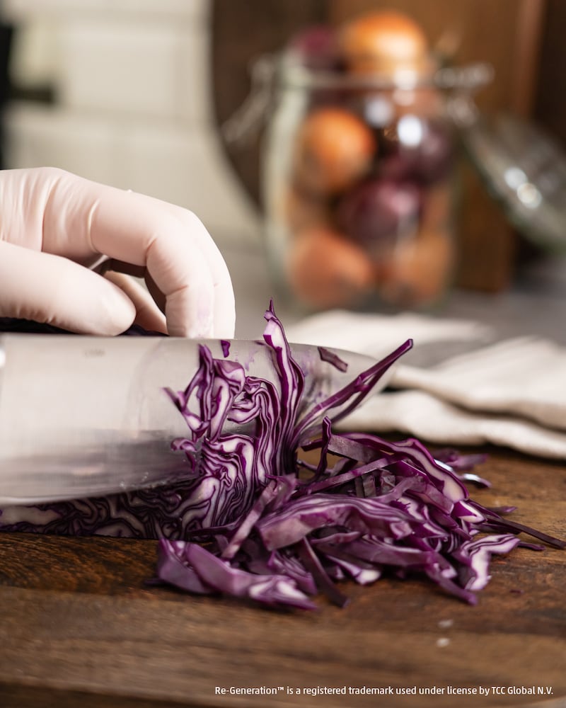 Dieses Bild zeigt wie ein Rotkohl mit einem Messer geschnitten wird.