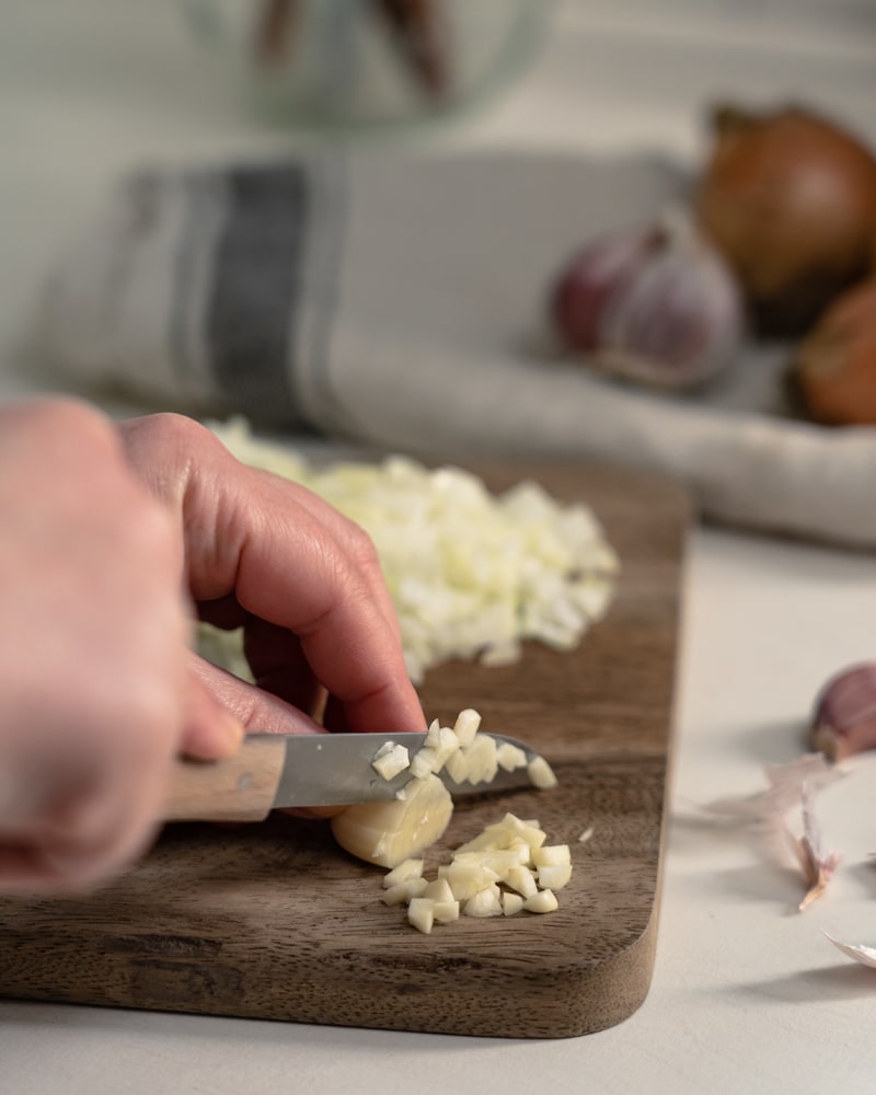 Auf diesem Bild siehst du wie Knoblauch geschnitten wird.