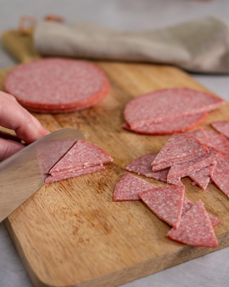 Dieses Bild zeigt wie Salami klein geschnitten wird.