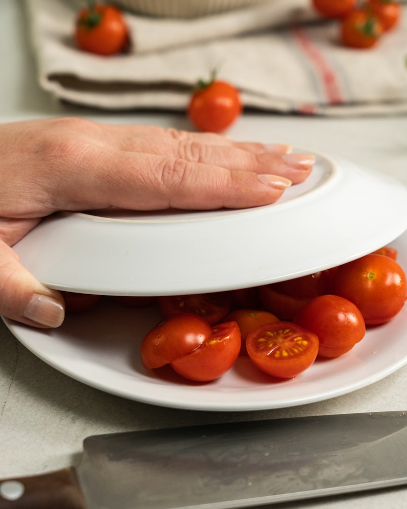 Auf diesem Bild siehst du wie Kirschtomaten halbiert werden.